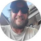 Smiling bearded man wearing sunglasses and a hat